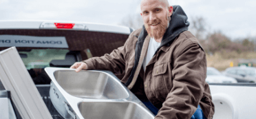 man moving sink from truck as a donation